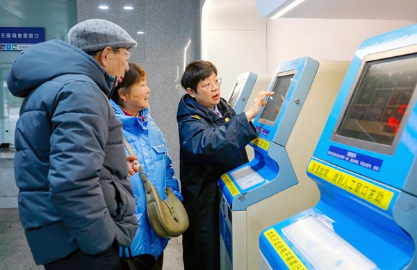 桂林车站售票员为老年旅客答疑解惑。郑长贤摄