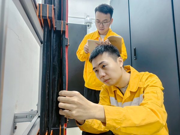 黄俊淋和职工一起检查机房线缆走向标签。邓哲摄