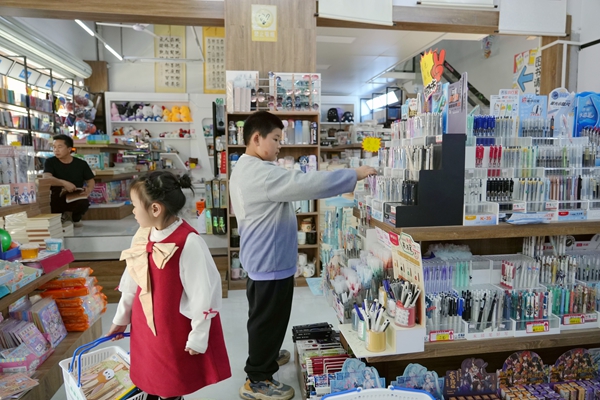 学生正在购买文具。王盛香摄