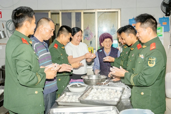 武警官兵與老人一同包元宵。