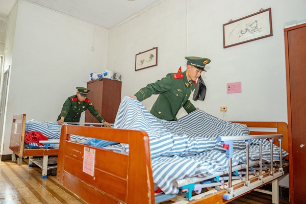 武警官兵為老人們打掃房間衛生。