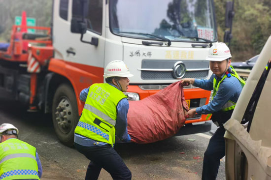 國門高速排障鐵軍隊員協助轉移事故車輛貨物。劉承繼攝