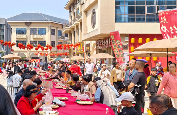 在特色美食长桌宴上，群众大快朵颐。