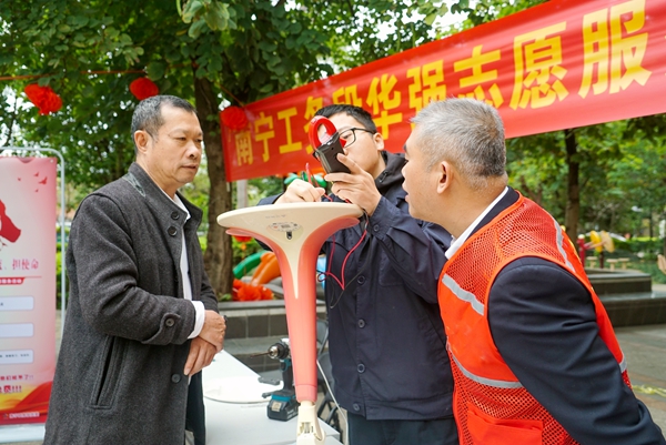 华强志愿服务队为居民修理家电。宋彤波摄