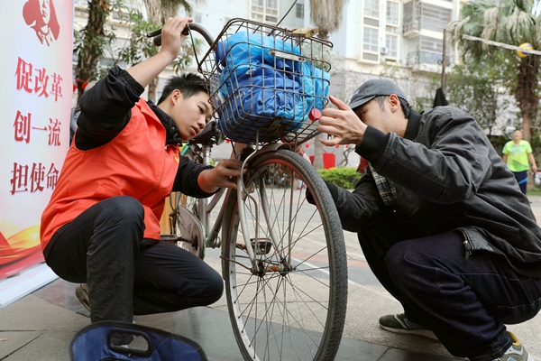 华强志愿服务队队员为居民修理自行车。庞敬业摄