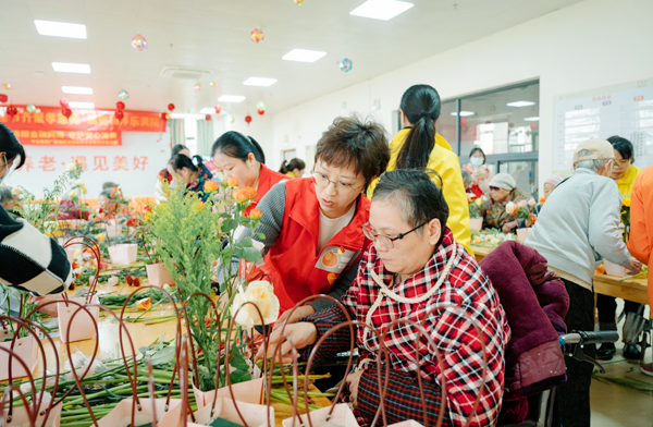 平安党员代表帮助长者插花。平安产险广西分公司供图