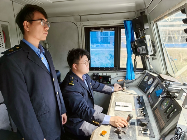 跨境司机在驾驶室内精准操作列车。