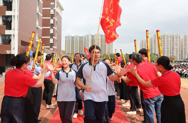 学生们踏上红毯，跨越“成功门”。