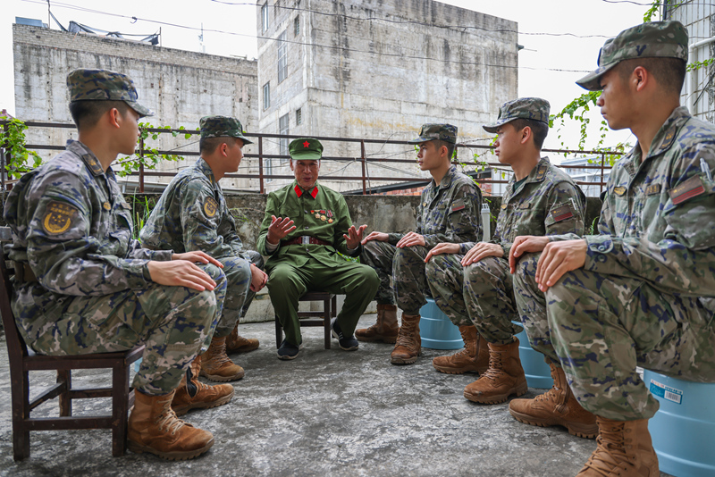 官兵静坐聆听老兵讲述战斗故事。温羽华摄