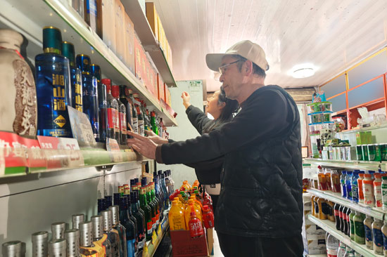 桂林烟草工作人员协助零售户整理店铺 唐蕙芳