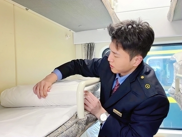 列车员李少杰细心整理卧铺铺位，抚平被子上的褶皱。庞军摄