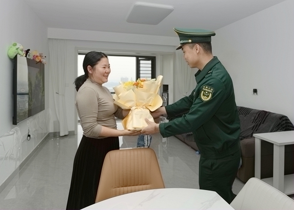 官兵为军嫂送上鲜花祝福。李家涛摄