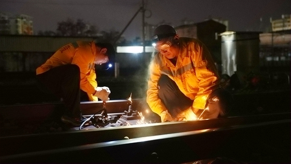 作業人員對鋼軌進行打磨。陳健攝