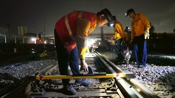 作業人員使用測量工具對鋼軌進行測量。陳健攝