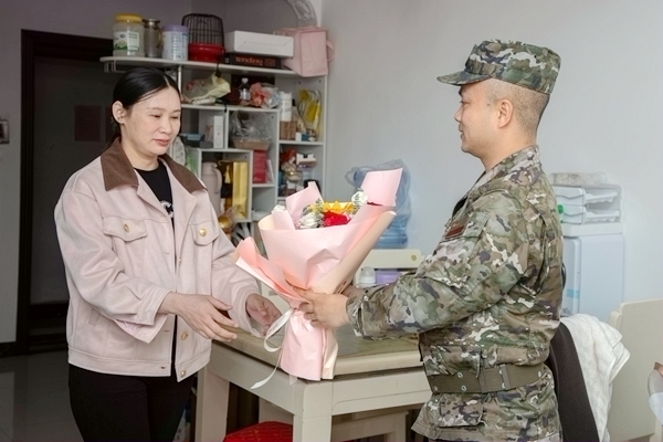 武警官兵向軍屬送上鮮花和慰問信。