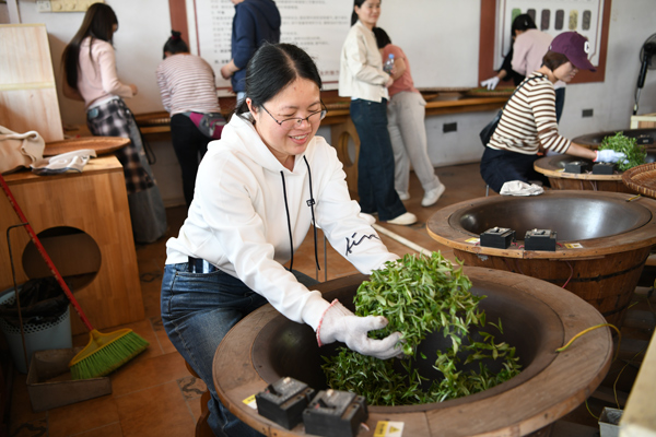 女职工体验手工炒茶。郭晨鑫睿摄