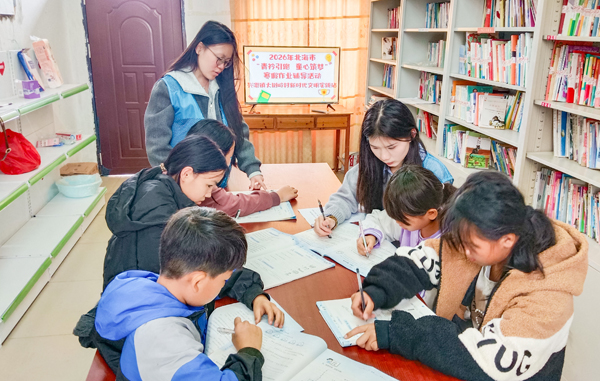 大学生志愿者在农家书屋为孩子们辅导课业