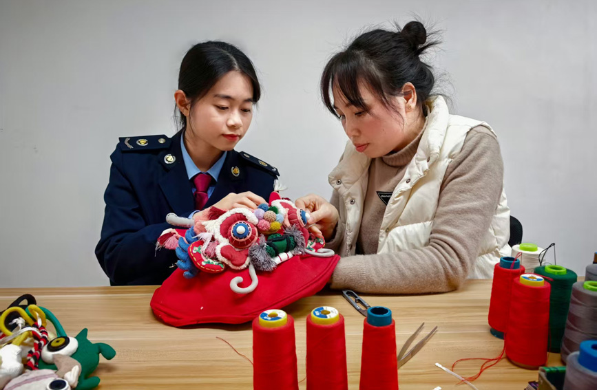 稅務干部協助繡娘完成繡品，“面對面”交流非遺手作經營情況，精准推送稅費優惠政策。任斯林攝