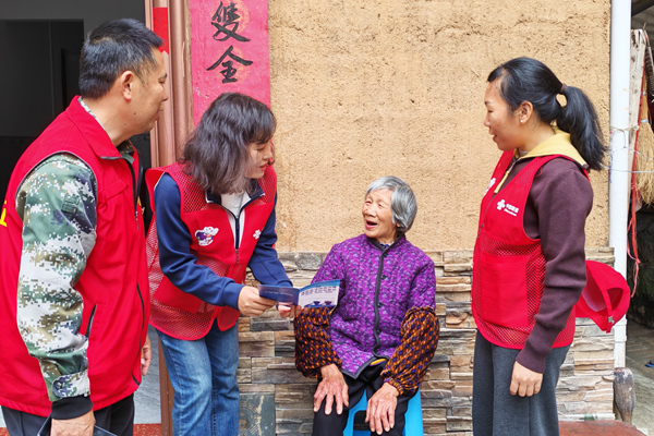 “联通小象”志愿者结合真实案例发放反诈宣传折页，提醒老人“不轻信、不转账”。广西联通供图_副本