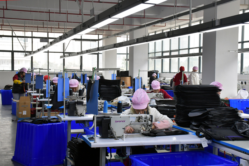 广西富美达箱包有限公司工人在缝制箱包。