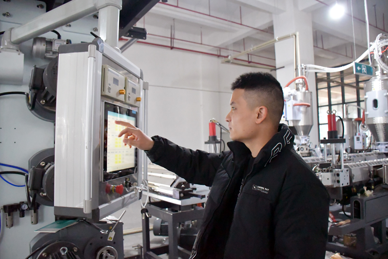 贺州市天佑箱包有限公司工人在调试设备。