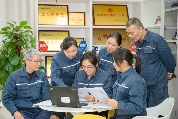 覃及翠（左三）组织班员集中研究优化数字化应用（韦振宏摄）