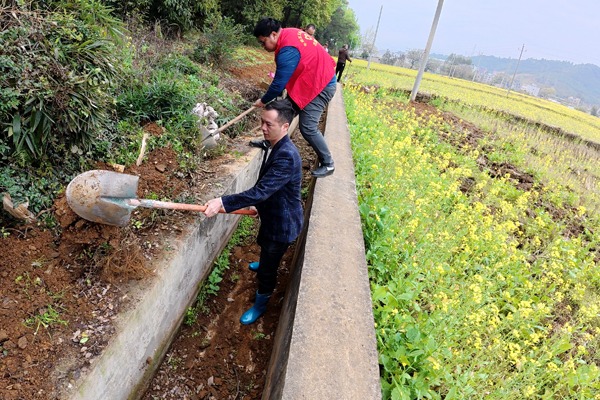 党员干部群众在清理水渠淤泥和杂草。