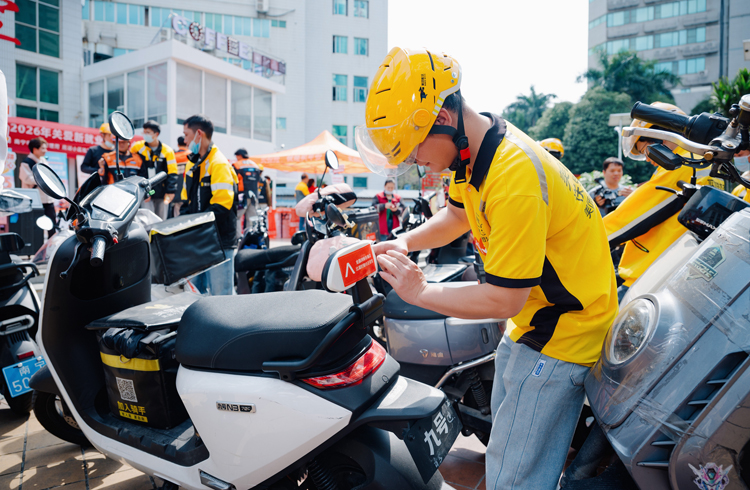 一位外卖骑手将专属反诈宣传贴粘在自己的电动车上。平安人寿广西分公司供图