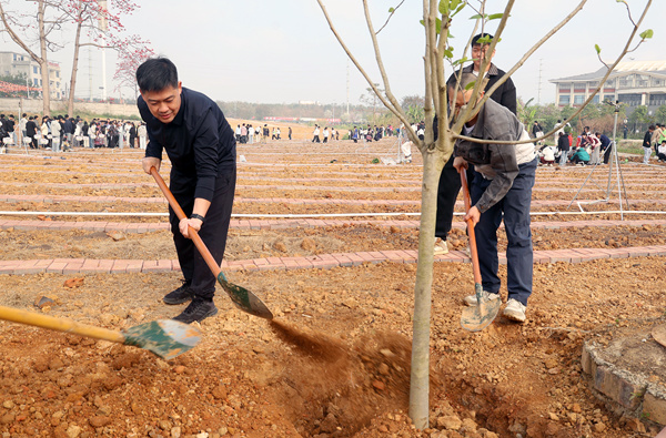 校领导与师生一同植树。莫军摄