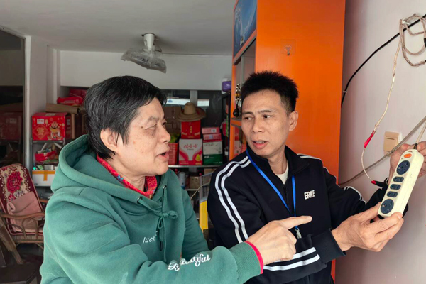 工作人员向零售户宣传电气使用安全知识。严燕军摄