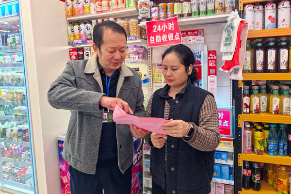 工作人员向零售户宣传法律法规知识。周长军摄