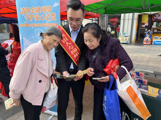 志愿者向社区居民讲解宣传手册内容。江泉摄