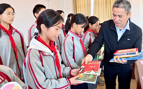 把新书递到孩子手中。韩佑存摄