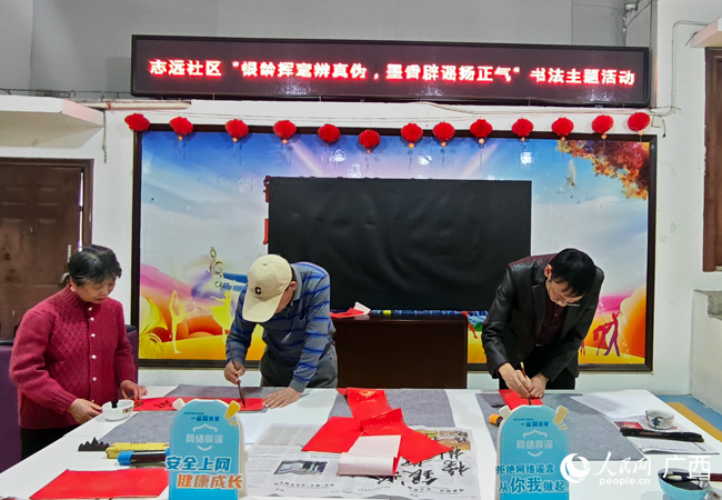 志愿者正在书写辟谣知识的对联。人民网记者 王勇摄