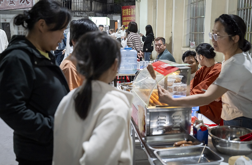 市民球迷在賽事現場特色攤位前採購當地農特產品。楊遠航攝