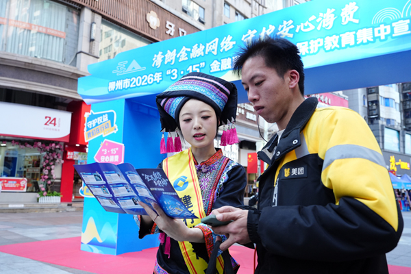 工作人员向外卖配送员讲解金融知识。建行柳州分行供图