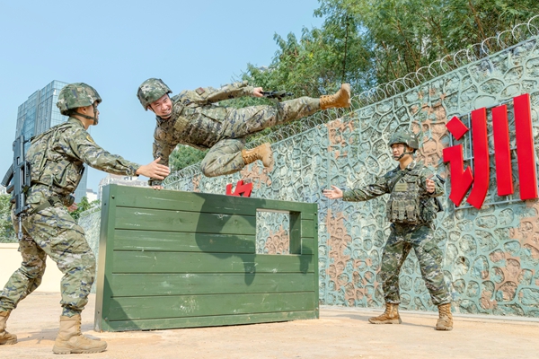 武警官兵在飛躍矮牆。