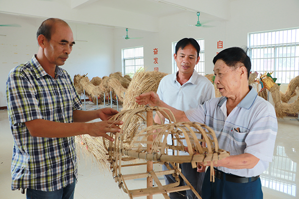 龙头乡三代草龙制作技艺传承人在一起制作草龙。扶绥县融媒体中心供图