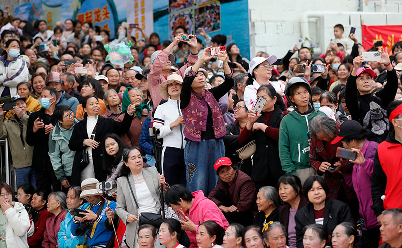 活动现场人头攒动，大家举着手机记录民俗盛况。卢文斐摄