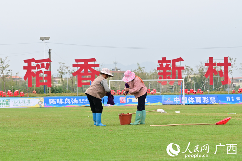 村民正在为球场吸水。人民网记者 雷琦竣摄