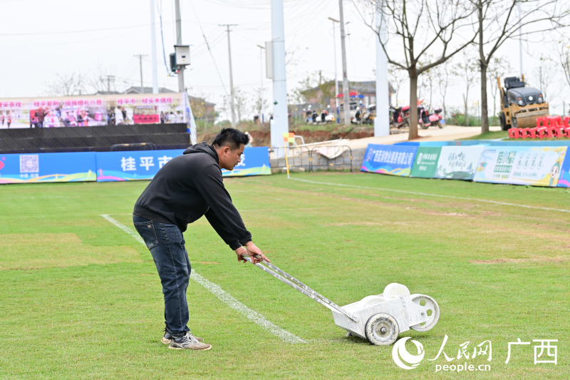 村民为球场重新描线。人民网记者 雷琦竣摄