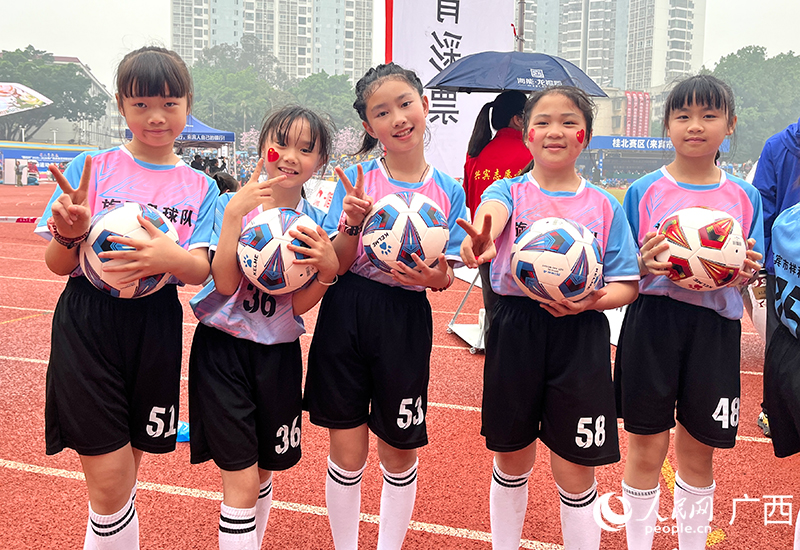 学生们抱着足球开心合影。人民网 韦欢摄