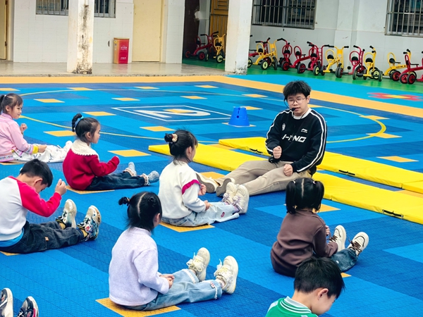 杨紫强老师给幼儿园小朋友做示范动作。