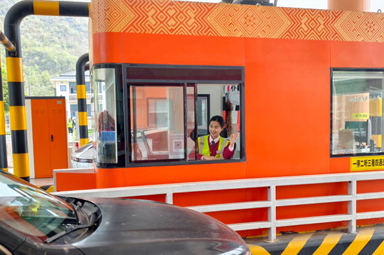 图为恭城分公司灌阳收费站收费员指挥车辆通行 卿椿桃摄 (2)