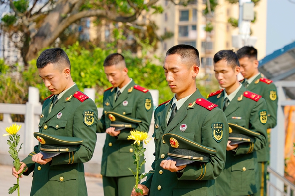 武警官兵神情凝重，肃穆默哀。