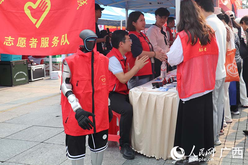 人形机器人主动与群众握手互动。人民网 刘璐瑶摄