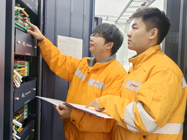 图2 梁邦乐在标准化机房建设中，为新职工传授通信设备业务知识。李秀莲摄