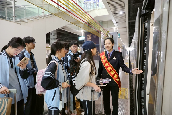 南宁车站研学服务队成员在车厢门口引导学生乘车。于莉摄