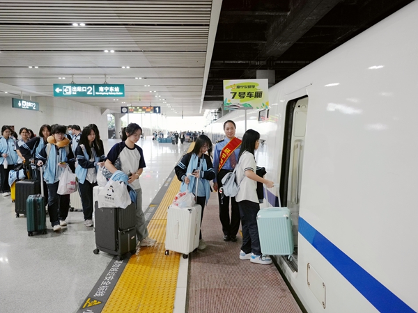 南宁东站研学服务队成员组织学生旅客有序上车。麦竹娴摄