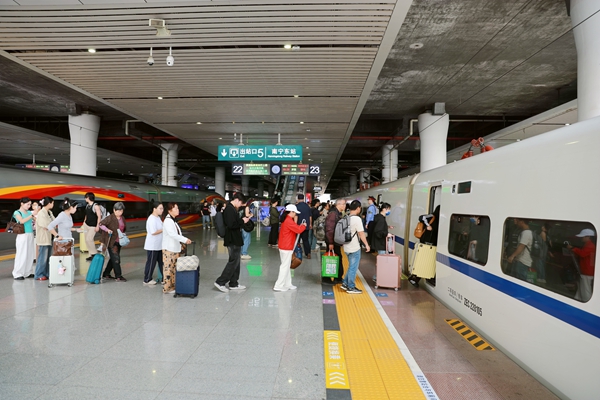 南宁东站站台旅客有序乘降。
